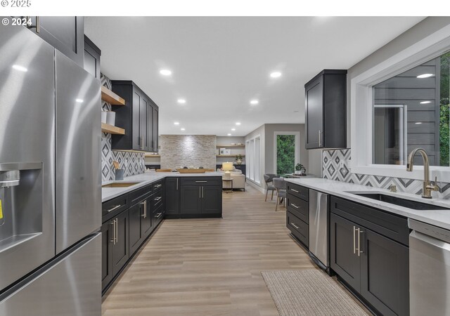 kitchen with a sink, open shelves, recessed lighting, stainless steel appliances, and light countertops