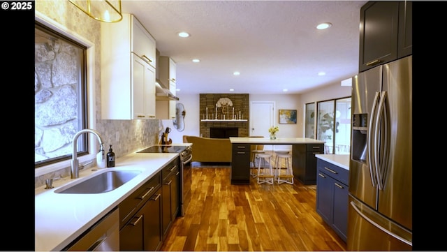 2280 NW 5th St, Gresham, OR 97030 - kitchen featuring a brick fireplace, wood finished floors, a sink, light countertops, and stainless steel appliances