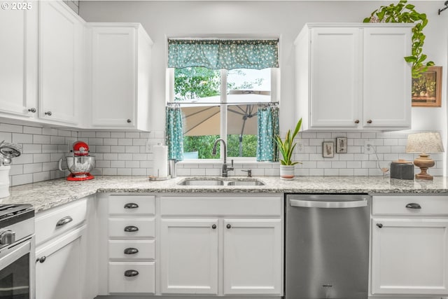 966 NW Brookhill St, Hillsboro, OR 97124 - kitchen featuring appliances with stainless steel finishes, a sink, white cabinetry, decorative backsplash, and light stone counters