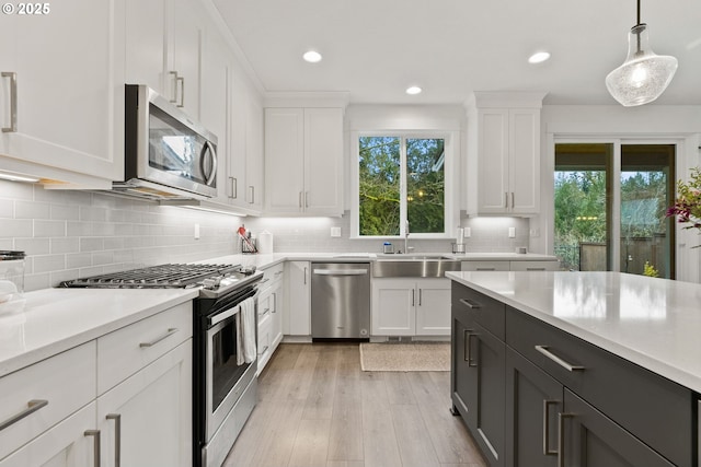 15955 SE Cherry Blossom Way, Happy Valley, OR 97015 - kitchen with appliances with stainless steel finishes, light countertops, white cabinetry, recessed lighting, and hanging light fixtures