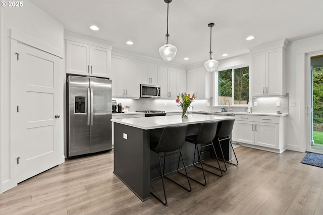 15955 SE Cherry Blossom Way, Happy Valley, OR 97015 - kitchen with appliances with stainless steel finishes, a center island, white cabinets, tasteful backsplash, and recessed lighting