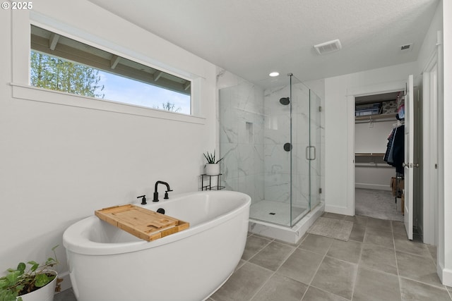 15955 SE Cherry Blossom Way, Happy Valley, OR 97015 - full bath featuring a soaking tub, a stall shower, a walk in closet, and tile patterned flooring