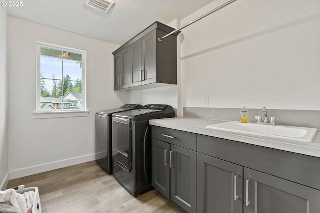15955 SE Cherry Blossom Way, Happy Valley, OR 97015 - laundry room with cabinet space, washer and clothes dryer, and light wood finished floors
