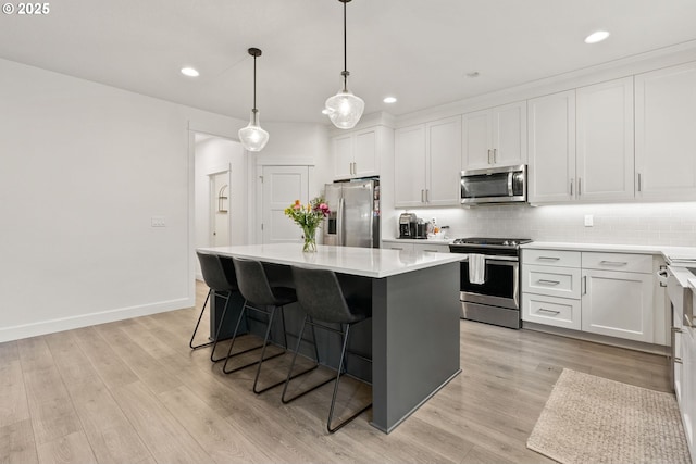 15955 SE Cherry Blossom Way, Happy Valley, OR 97015 - kitchen featuring stainless steel appliances, decorative backsplash, a center island, a kitchen bar, and recessed lighting
