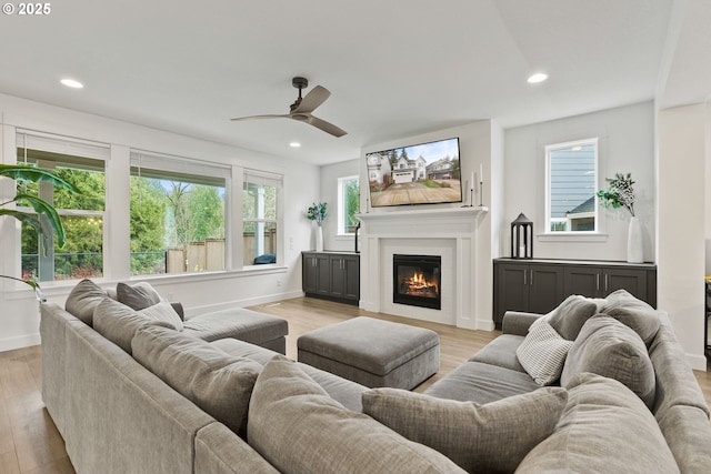 15955 SE Cherry Blossom Way, Happy Valley, OR 97015 - living area featuring a ceiling fan, a glass covered fireplace, light wood finished floors, and recessed lighting