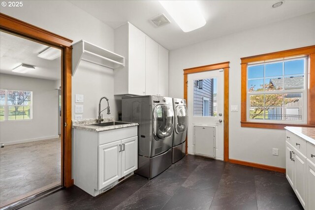 washroom with washer and dryer, baseboards, and cabinet space