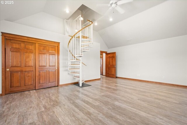 entryway featuring stairs, wood finished floors, a ceiling fan, baseboards, and high vaulted ceiling