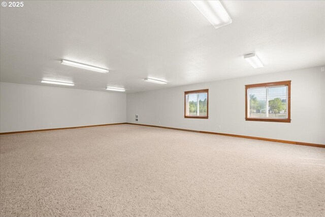carpeted empty room featuring baseboards