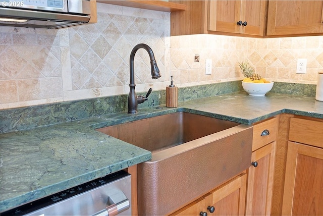 kitchen with a sink, stainless steel dishwasher, and tasteful backsplash