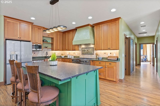 kitchen with premium range hood, stainless steel appliances, light wood-style floors, a center island, and recessed lighting