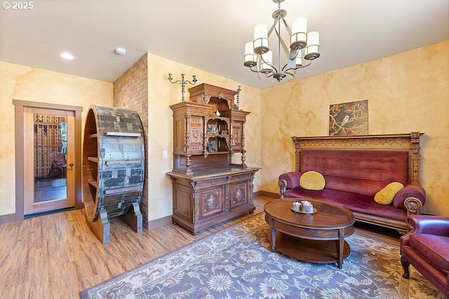 living room featuring light wood-style flooring, a chandelier, and baseboards