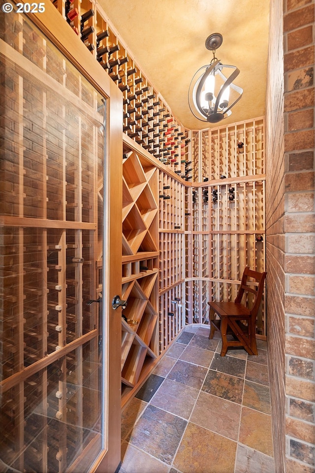 wine area with stone tile flooring and a chandelier