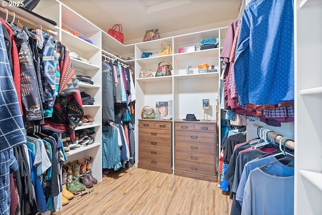 walk in closet featuring attic access and wood finished floors