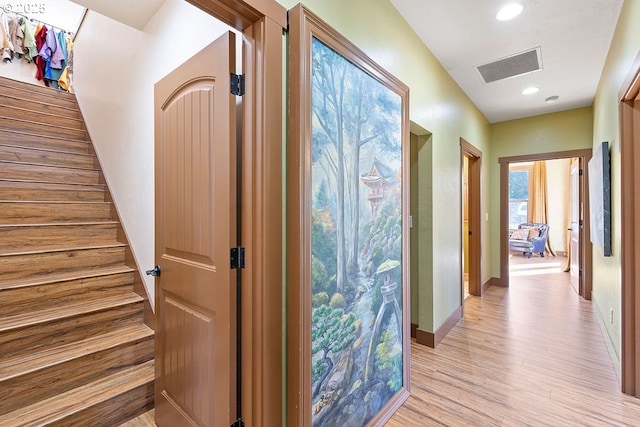 hall with stairs, light wood-style flooring, baseboards, and recessed lighting