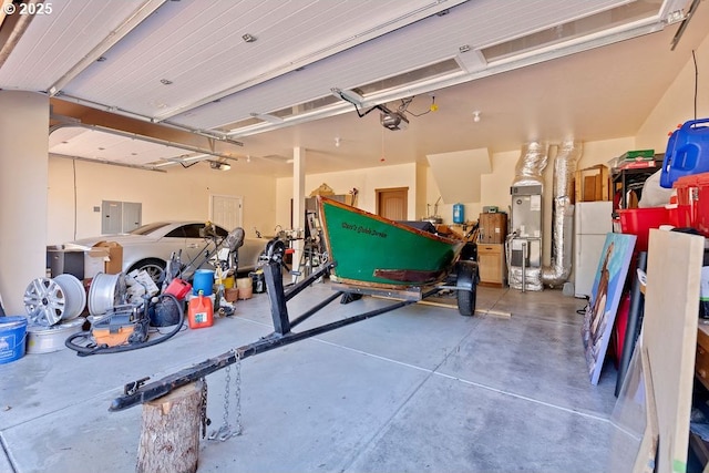 garage with a garage door opener, freestanding refrigerator, and electric panel