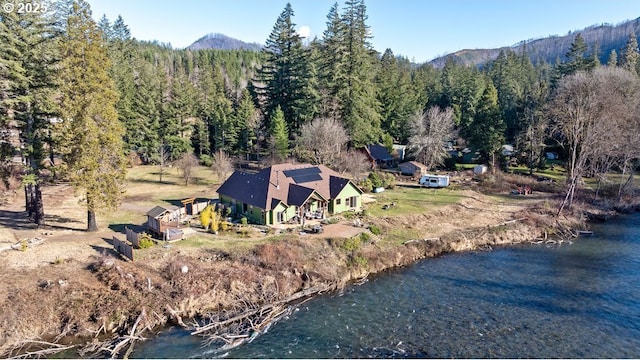 view from above of property featuring a forest and a water and mountain view