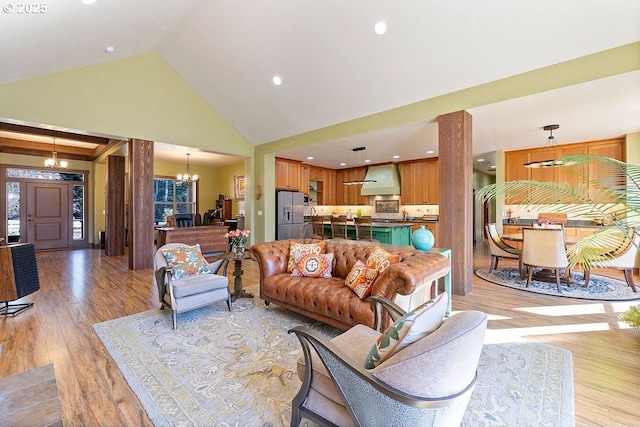 living area featuring a chandelier, light wood finished floors, high vaulted ceiling, and recessed lighting