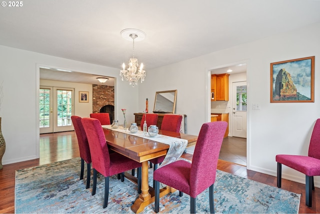 5239 Madrona St, Lake Oswego, OR 97035 - dining area with dark wood finished floors, a chandelier, and a brick fireplace