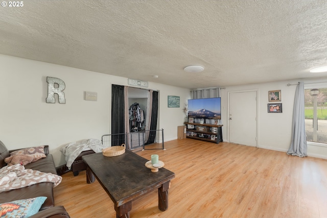 living room with light wood-style floors and a textured ceiling