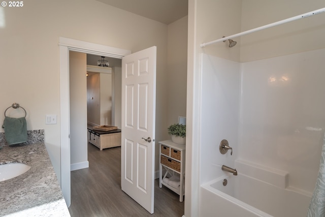 full bath featuring vanity, bathtub / shower combination, and wood finished floors