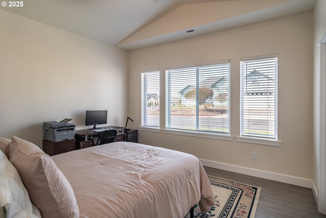 bedroom with visible vents, multiple windows, wood finished floors, and vaulted ceiling