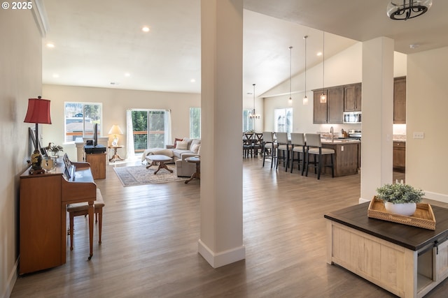 living area with recessed lighting, dark wood-type flooring, baseboards, and vaulted ceiling