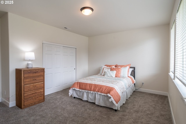 carpeted bedroom featuring baseboards, visible vents, and a closet