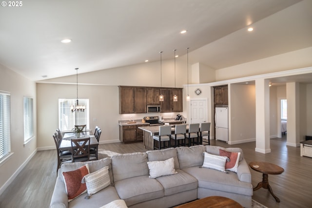 living room featuring wood finished floors, baseboards, recessed lighting, vaulted ceiling, and a chandelier