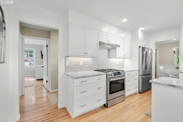 630 9th St, Lake Oswego, OR 97034 - kitchen featuring appliances with stainless steel finishes, under cabinet range hood, light wood-style floors, white cabinetry, and recessed lighting