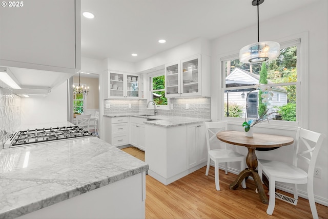 630 9th St, Lake Oswego, OR 97034 - kitchen with a chandelier, decorative backsplash, light stone counters, light wood-style flooring, and recessed lighting