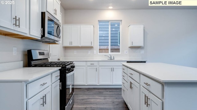 kitchen with dark wood-type flooring, sink, white cabinets, and stainless steel appliances