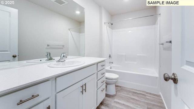 full bath with visible vents, toilet, vanity, shower / tub combination, and wood finished floors