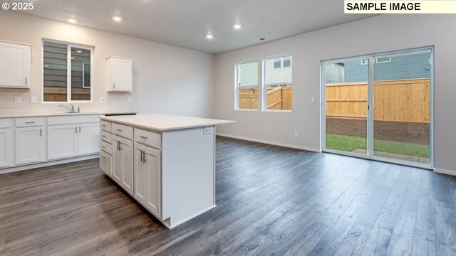 kitchen with white cabinets, a kitchen island, and dark hardwood / wood-style floors