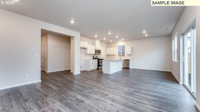 kitchen featuring white cabinets, stainless steel appliances, a center island, and dark hardwood / wood-style flooring