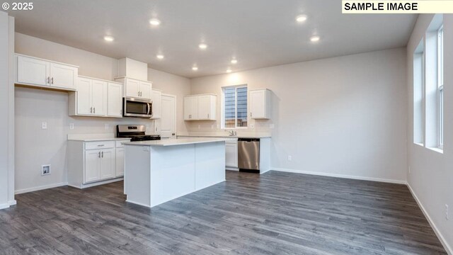 kitchen featuring white cabinetry, dark hardwood / wood-style floors, a center island, and stainless steel appliances