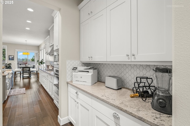 6435 SE Ketchum St, Milwaukie, OR 97267 - kitchen with recessed lighting, dark wood-style flooring, white cabinetry, backsplash, and light stone counters