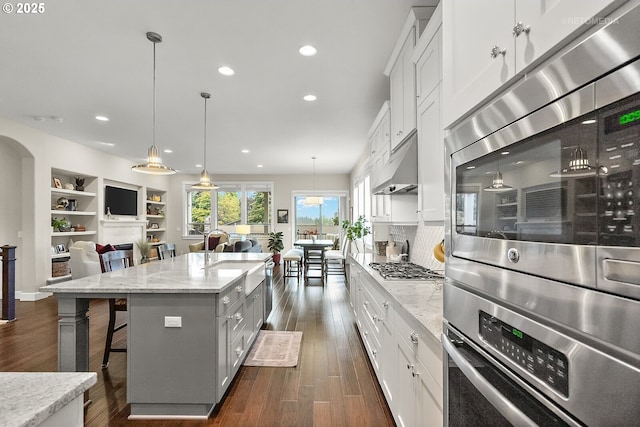6435 SE Ketchum St, Milwaukie, OR 97267 - kitchen with under cabinet range hood, recessed lighting, a breakfast bar, open floor plan, and dark wood-style flooring