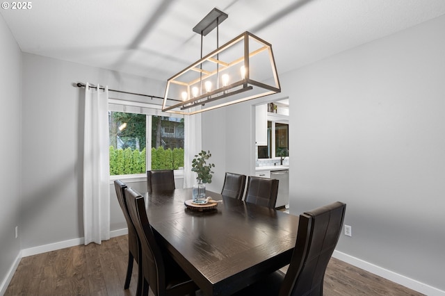 dining area featuring an inviting chandelier, wood finished floors, and baseboards