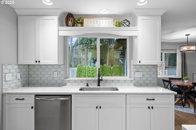 kitchen featuring a wealth of natural light, white cabinets, a sink, and stainless steel dishwasher