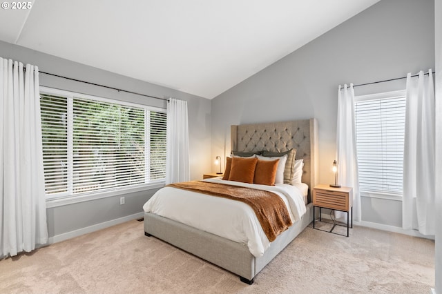 carpeted bedroom with vaulted ceiling and baseboards