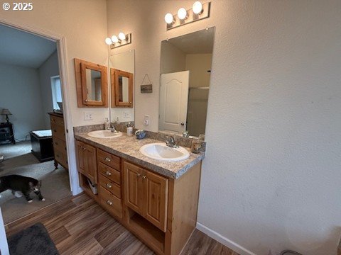 24985 Hunter Ave, Veneta, OR 97487 - bathroom with wood finished floors, double vanity, vaulted ceiling, and baseboards