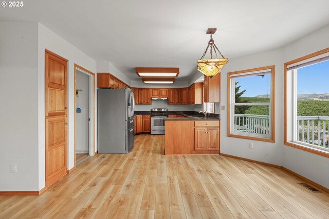 kitchen with dark countertops, light wood-style flooring, visible vents, and stainless steel appliances