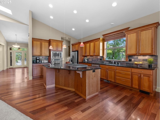 kitchen featuring a center island, lofted ceiling, stainless steel appliances, and tasteful backsplash