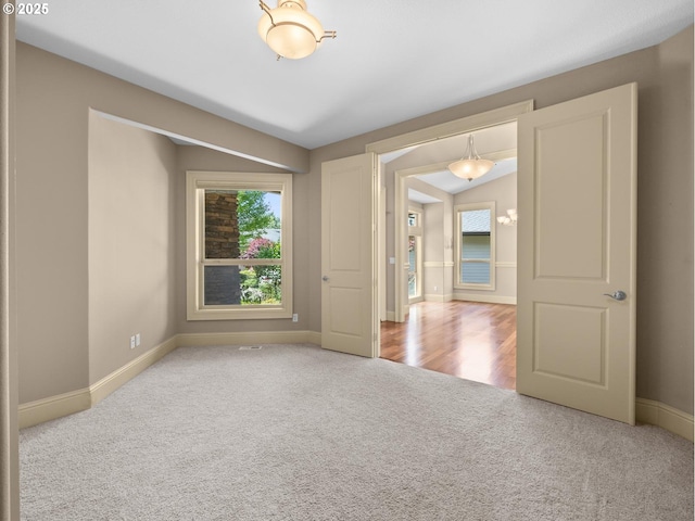 unfurnished room featuring carpet flooring and lofted ceiling