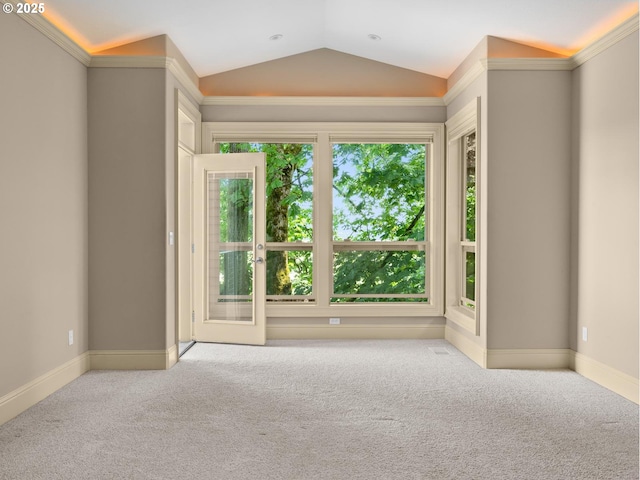 empty room with light colored carpet, vaulted ceiling, and ornamental molding