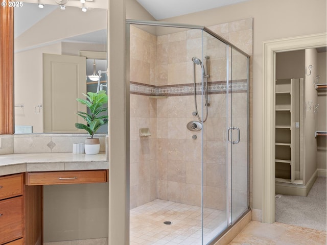 bathroom featuring vaulted ceiling and a shower with shower door