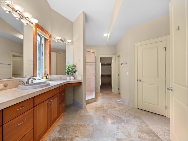 bathroom featuring tiled shower and vanity