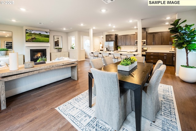 23623 SW Landon Pl, Tualatin, OR 97062 - dining area with a glass covered fireplace, recessed lighting, wood finished floors, and baseboards