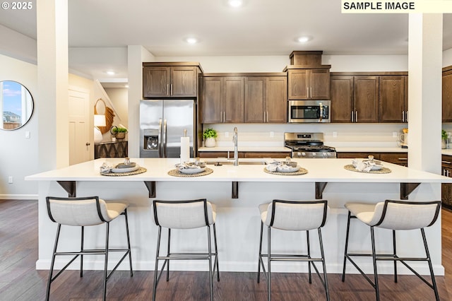 23623 SW Landon Pl, Tualatin, OR 97062 - kitchen featuring stainless steel appliances, a center island with sink, a kitchen breakfast bar, light countertops, and recessed lighting