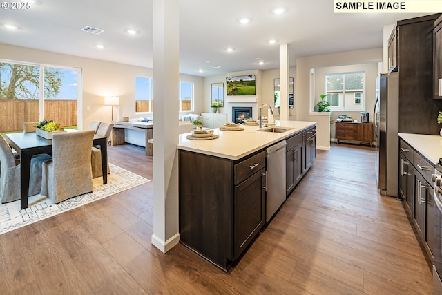 23623 SW Landon Pl, Tualatin, OR 97062 - kitchen with a sink, stainless steel appliances, open floor plan, dark brown cabinets, and light countertops
